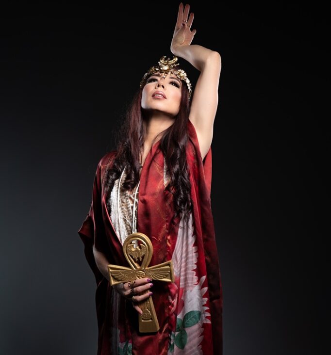 Meliana Solara as Kundalini Priestess holding a golden ankh, wearing a red sacred robe – embodiment of kundalini energy, feminine power and spiritual awakening