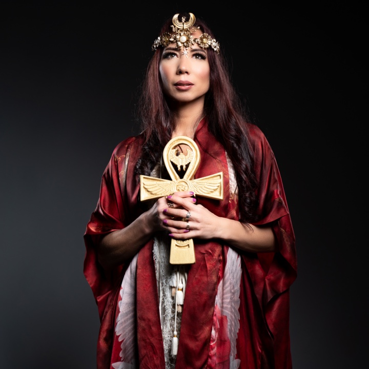 Meliana Solara as Kundalini Priestess holding a golden ankh with flowing red veil – sacred feminine energy and kundalini embodiment